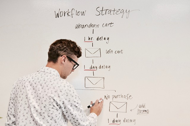 Man drawing flow chart on a whiteboard