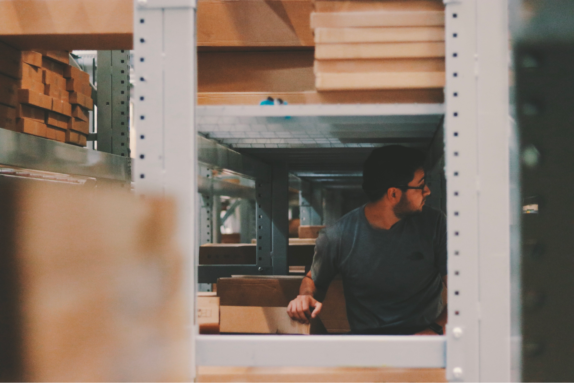Warehouse worker surrounded by shelving units preparing shipments that trigger EDI 856 advance ship notice documents