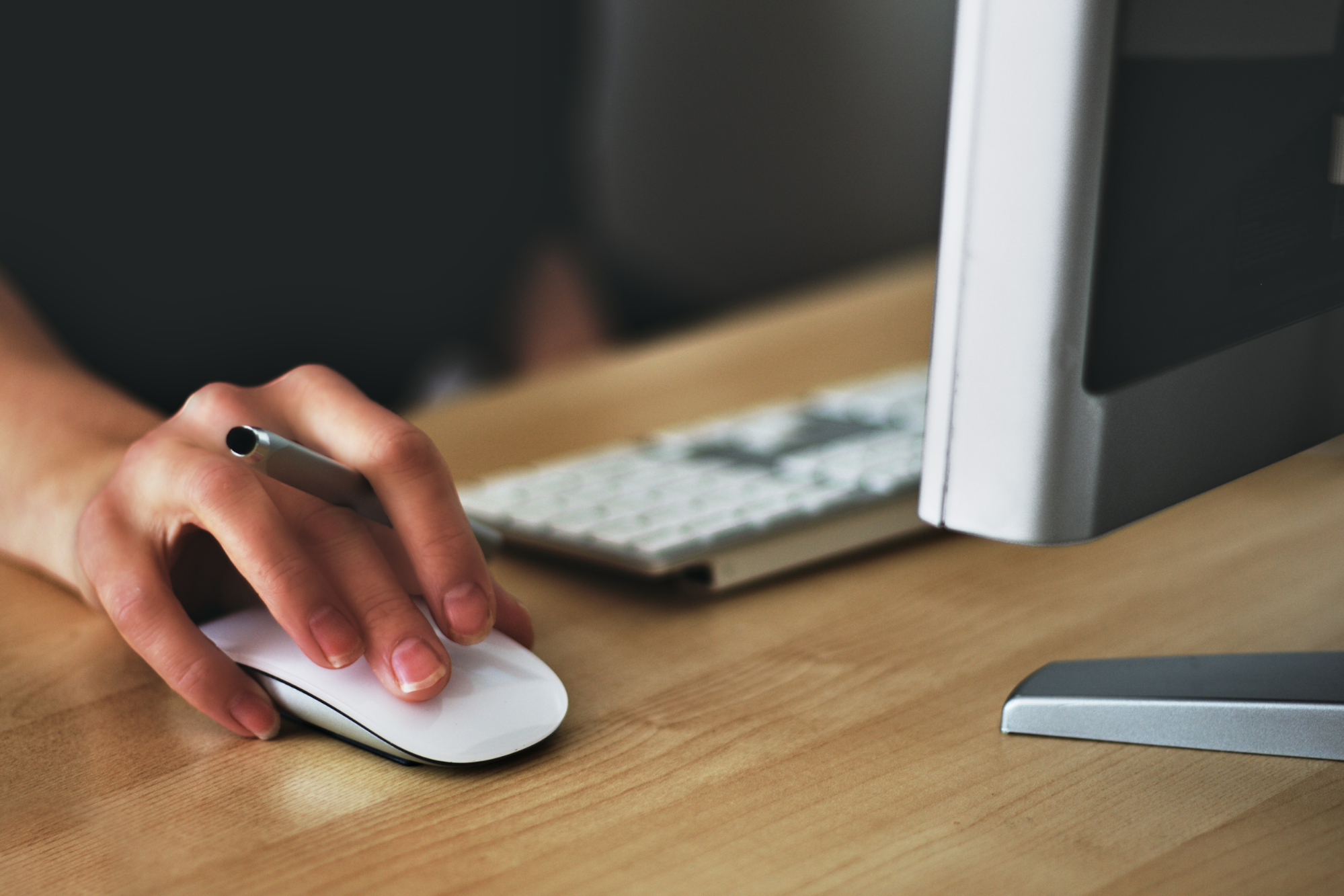 A hand holding and clicking a computer mouse