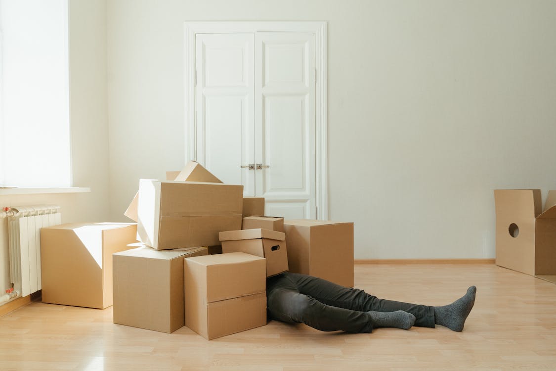 A dropshipper buried under a pile of returned order boxes. 