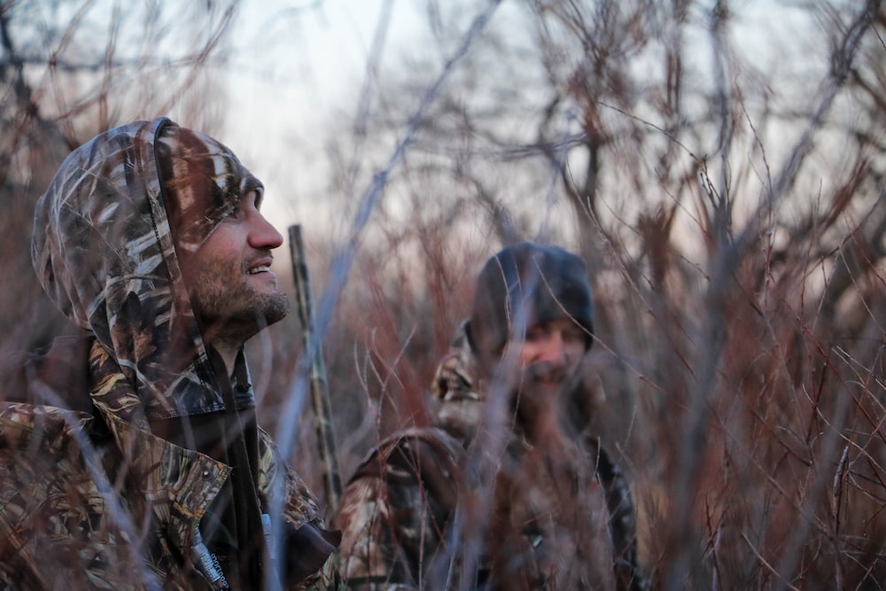 Hunters walking through a forest. 