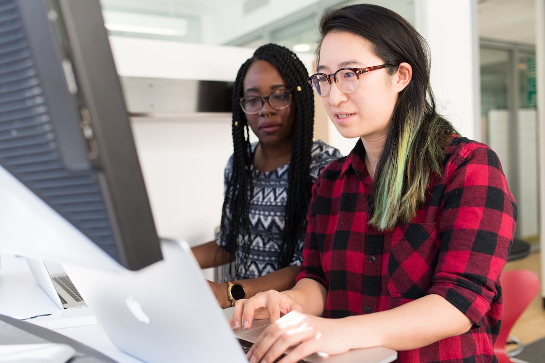 Two women working together on a laptop