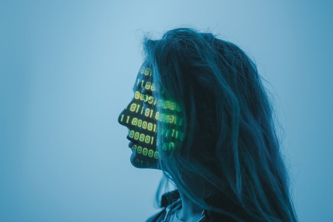 A person with binary code projected onto their face.