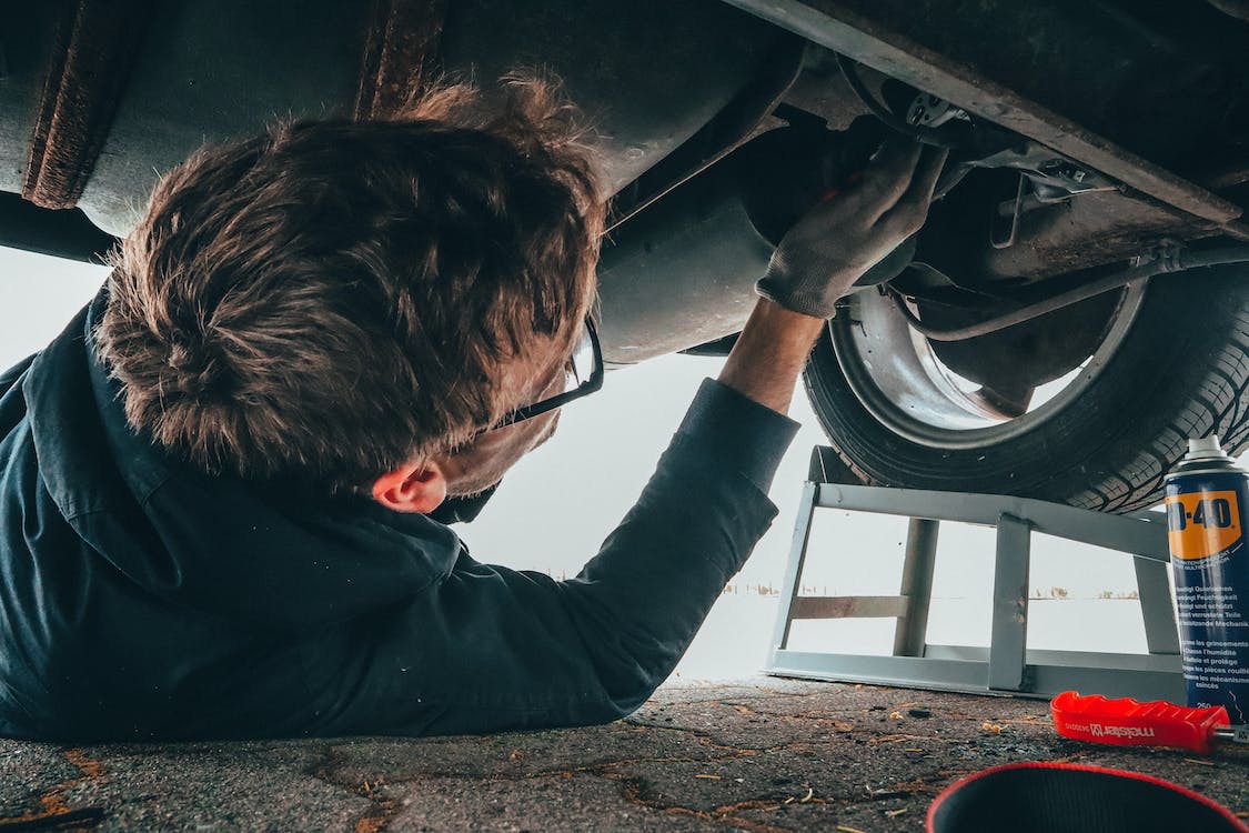 Man fixing the underside of a car
