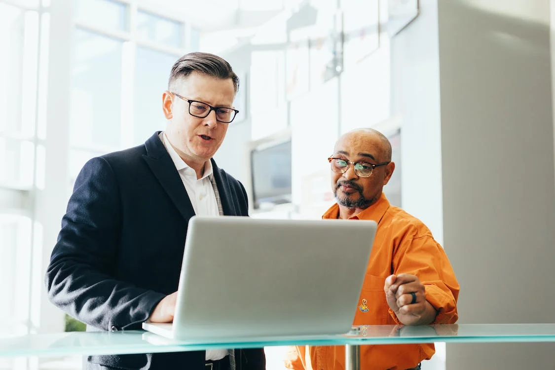 Two people looking at a laptop screen