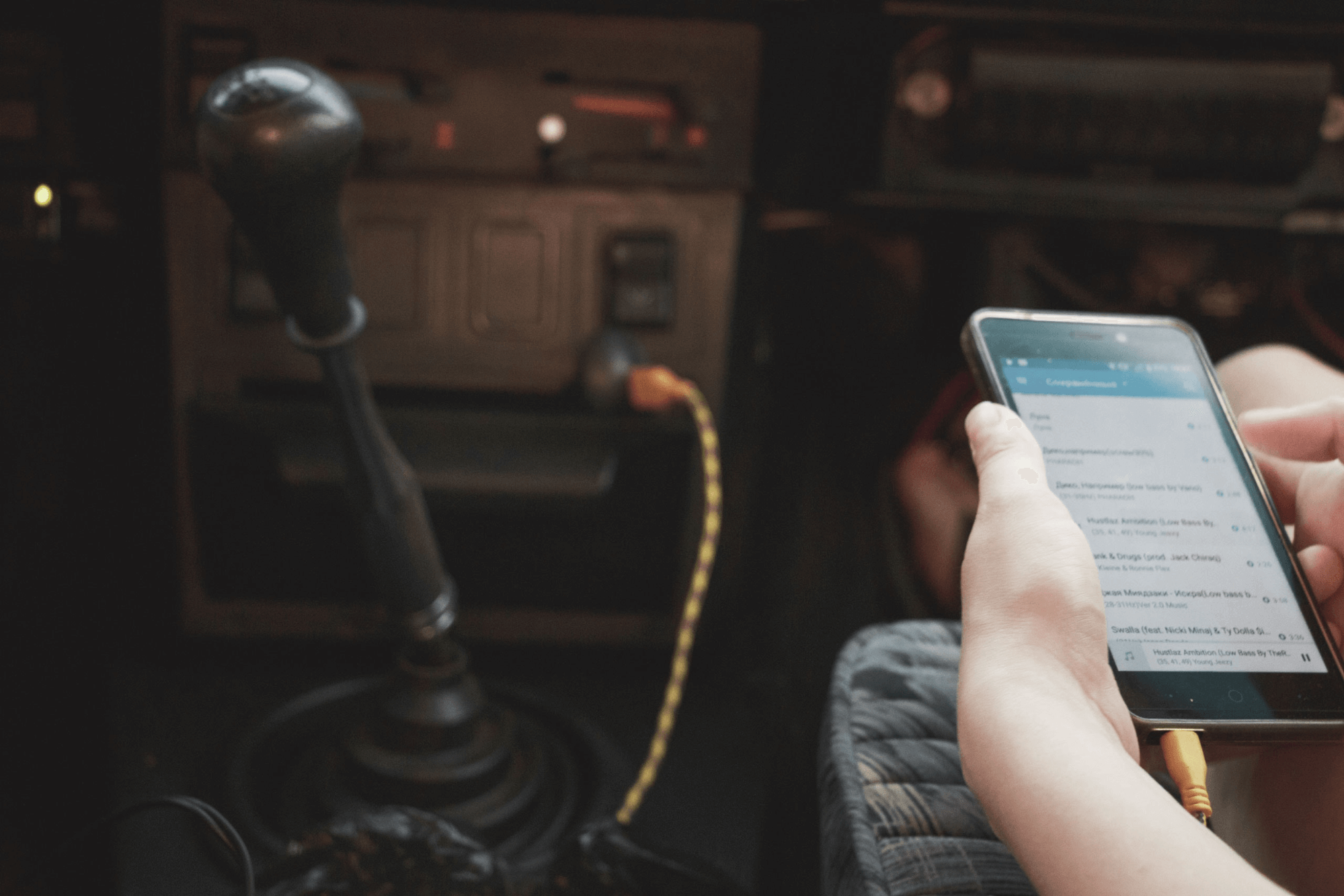 Person holding a phone inside a car