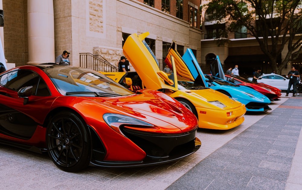 Luxury sports cars parked at an automotive tradeshow.