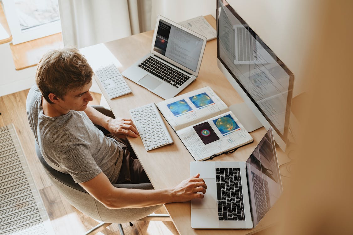 Person working at desk with three screens