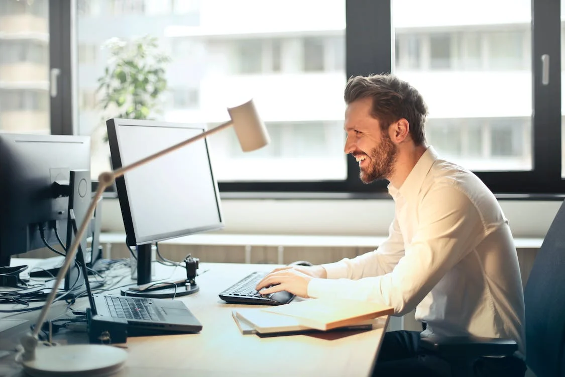 Person smiling whilst working at computer