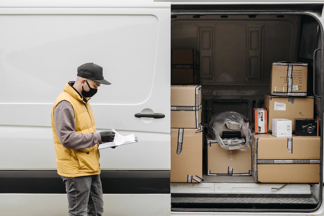 A courier loading returned orders in their van. 