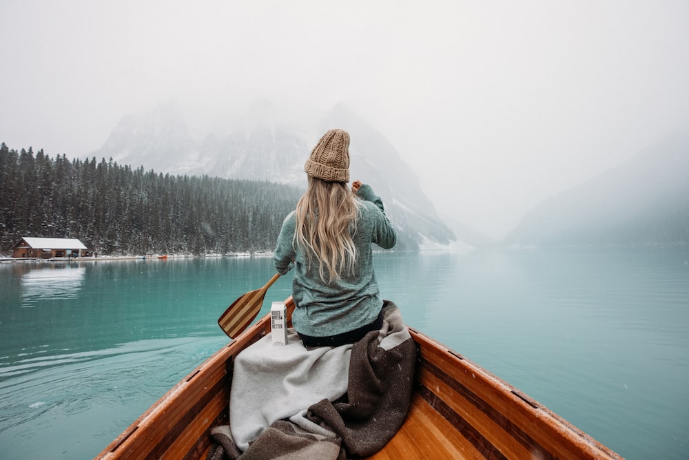 Person kayaking on a wintry lake.