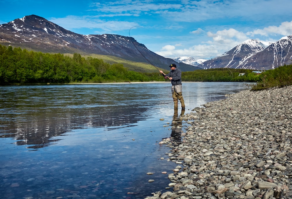 Man fishing with gear bought from a fishing equipment ecommerce store.