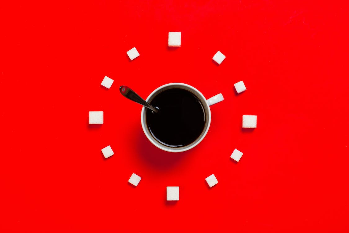 Image on an analog clock with a coffee cup at its centre