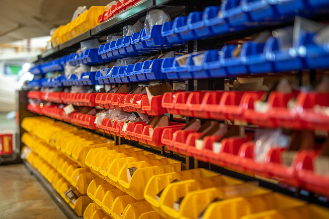 rows of red, yellow, and blue organizers holding small parts and products